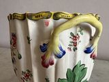 a vase that has a handle on it on a table