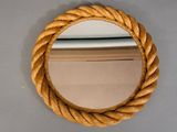 un miroir rond accroché au mur, entouré d'une corde