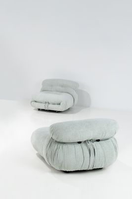 une pièce blanche avec deux chaises et deux coussins posés par terre