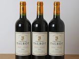 trois bouteilles de vin rouge posées sur une table en bois