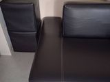 un canapé en cuir noir et un fauteuil dans un salon