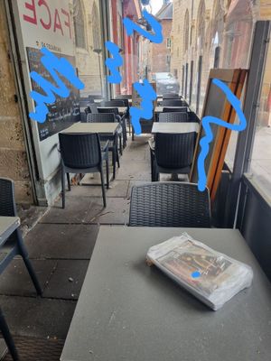 une table sur laquelle est posé un journal, devant une fenêtre