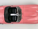an overhead view of a pink car on a white surface