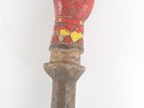 une vieille sculpture en bois représentant la tête d'un homme, fixée sur un poteau en bois