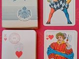 trois cartes à jouer sont posées les unes à côté des autres sur une surface rose