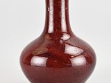 a red vase that is sitting on a white surface