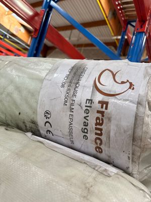 un rouleau de tissu posé par terre dans un entrepôt