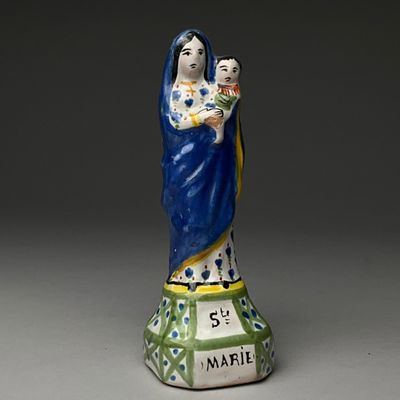 figurine d'une femme tenant un enfant dans ses bras