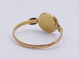 a close up of a gold ring on a white surface