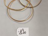 trois bracelets rigides en or sur fond blanc, avec une étiquette de prix