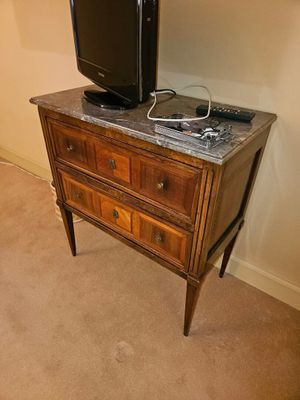 une télévision posée sur une commode dans un coin de la pièce