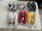 Plusieurs paires de chaussures sont emballées dans des sacs en plastique sur une table