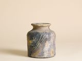 un petit vase posé sur une table