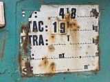 a rusted sign on the side of a blue wall