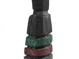 a wooden statue of a person standing next to a stack of bracelets