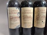 three bottles of red wine are lined up on a table
