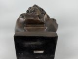 an image of a bronze statue of a lion on a black base