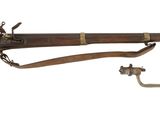 un vieux fusil avec un canon en bois et des accessoires en laiton sur fond blanc