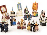 a group of figurines of people dressed in historical costumes