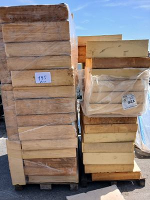 plusieurs piles de palettes en bois empilées les unes sur les autres dans un parking