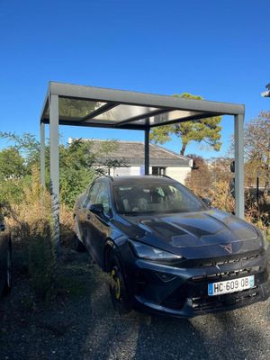 une voiture noire garée sous un auvent dans un parking