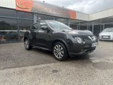a black nissan juke parked in front of a building