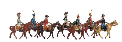 seven figurines of men riding horses on a white background