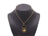 un collier plaqué or orné d'une image en noir et blanc représentant le visage d'une femme