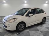 la petite voiture blanche est garée sur un sol en damier