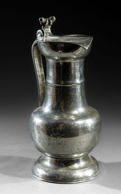 a silver pitcher that is sitting on a table
