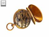 a gold pocket watch that has a key in it