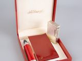 a red box with a pen, notebook and lighter in it