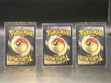 three plastic pokemon keychains sitting on top of a metal counter