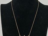 a gold necklace with a cross on a mannequin neck