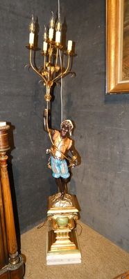 une statue d'ange posée sur une table, à côté d'une lampe