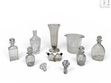 de nombreuses bouteilles et vases en verre posés sur une surface blanche