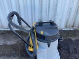 un aspirateur posé par terre près d'un mur