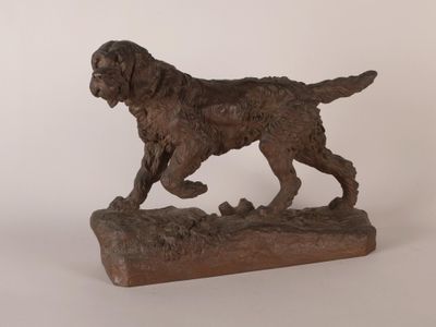statue d'un chien en train de courir, posée sur un socle en bois, sur fond blanc