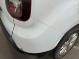 a white car that has been damaged and is parked in a parking lot