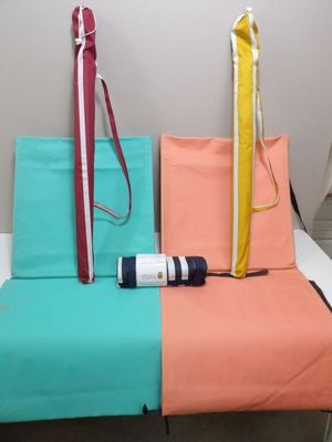 a bed with a blue, orange, and pink cover and a bag on it