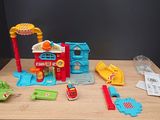 a small table with toys on it that include a fire truck and a fire station