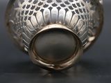a silver vase with a pearl in it on a table