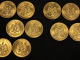 a close up of a bunch of gold coins on a black surface