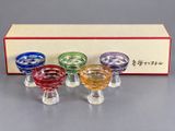 four small glass bowls are sitting in front of a box