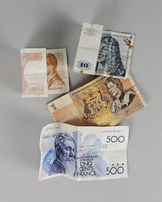quatre billets de banque de devises différentes posés les uns sur les autres
