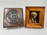deux plaques en bronze représentant un homme et une femme, dans un cadre en bois