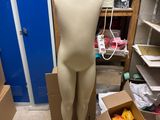 un mannequin dans une boîte en carton au milieu d'une pièce