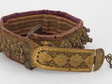 une vieille ceinture avec une boucle métallique sur un fond blanc