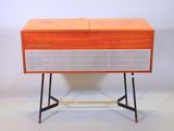 une radio orange et blanche posée sur une table en bois