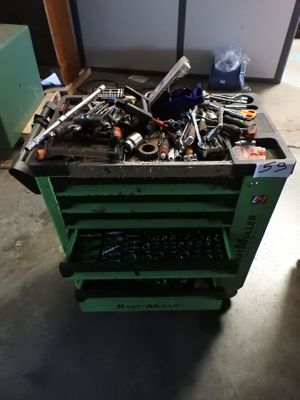 a green cart with tools on it in a garage